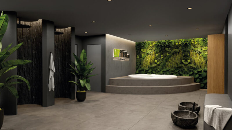 Moderner Spa-Raum in einem Fitnessstudio-Franchise mit großem, rundem Whirlpool auf erhöhten Stufen, grüner Pflanzenwand, dunklen Duschelementen, Topfpflanzen, Steinschalen und minimalistischer Beleuchtung. Sanftes, entspannendes Ambiente verbindet Natur mit elegantem Design.