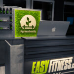 Ein moderner Empfangstresen im Fitnessstudio mit einem Laptop, einem beleuchteten EASY FITNESS EMS-Schild, Wasserflaschen auf einem Regal und einem grünen Wanddisplay mit einer Pflanze und dem Hashtag #greenfamily. Ein moderner Empfangstresen im Fitnessstudio mit einem Laptop, einem beleuchteten EASY FITNESS EMS-Schild, Wasserflaschen auf einem Regal und einem grünen Wanddisplay mit einer Pflanze und dem Hashtag #greenfamily.